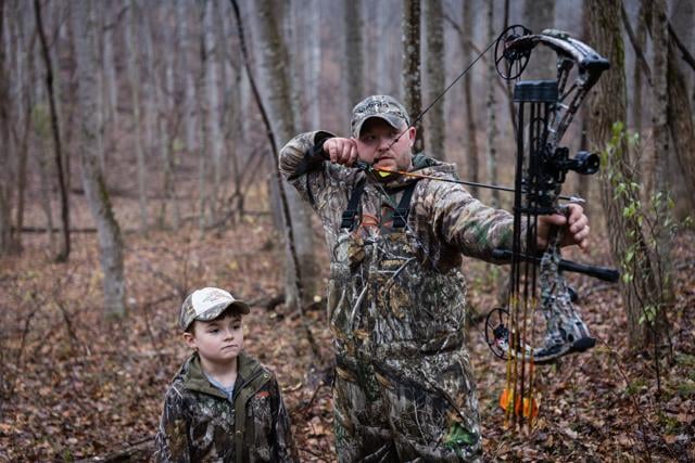 Mason who is eight is too young to bowhunt, but he treks out with his father, Roy, to learn the ways.
