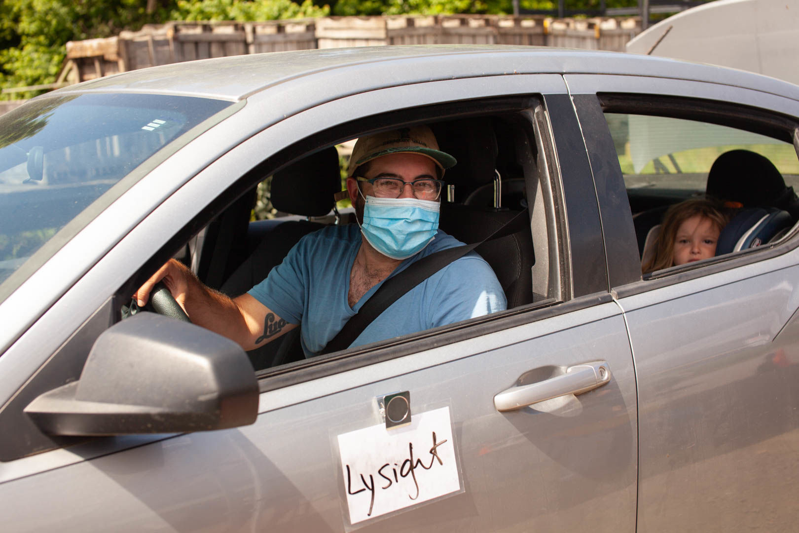 Eric Ralls, with daughter, Mira, drive through the market picking up different goods.