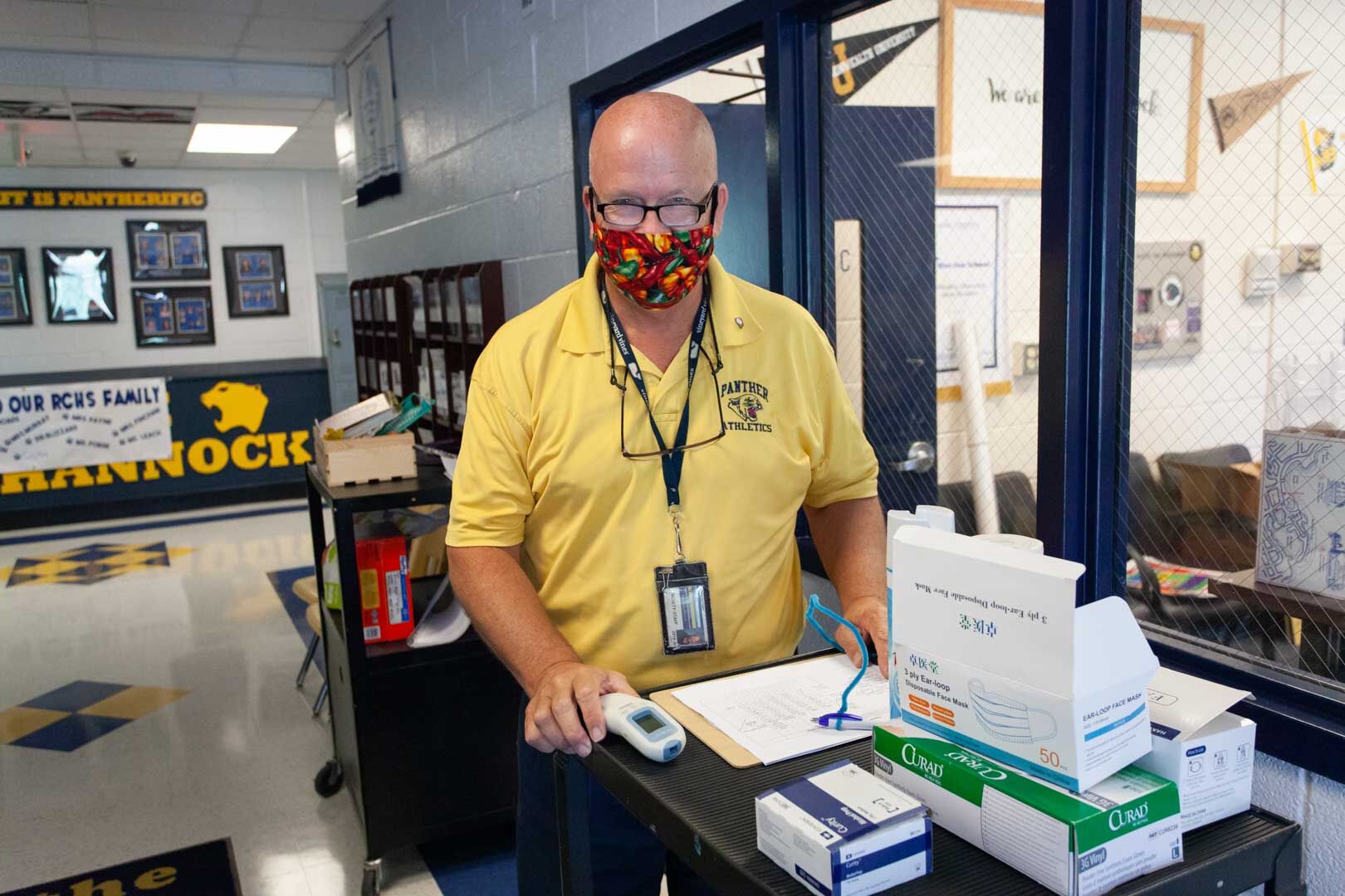 High School Principal Jimmy Swindler gives a wellness questionnaire at the portico entrance.
