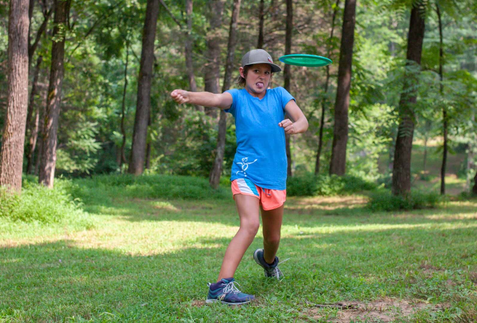 M.J. Gager, a nine-year-old who recently won a world championship title, throws a disc in Spilman Park. Her dad, Tommy Gager, said M.J. sticking her tongue out is her signature "concentration face."