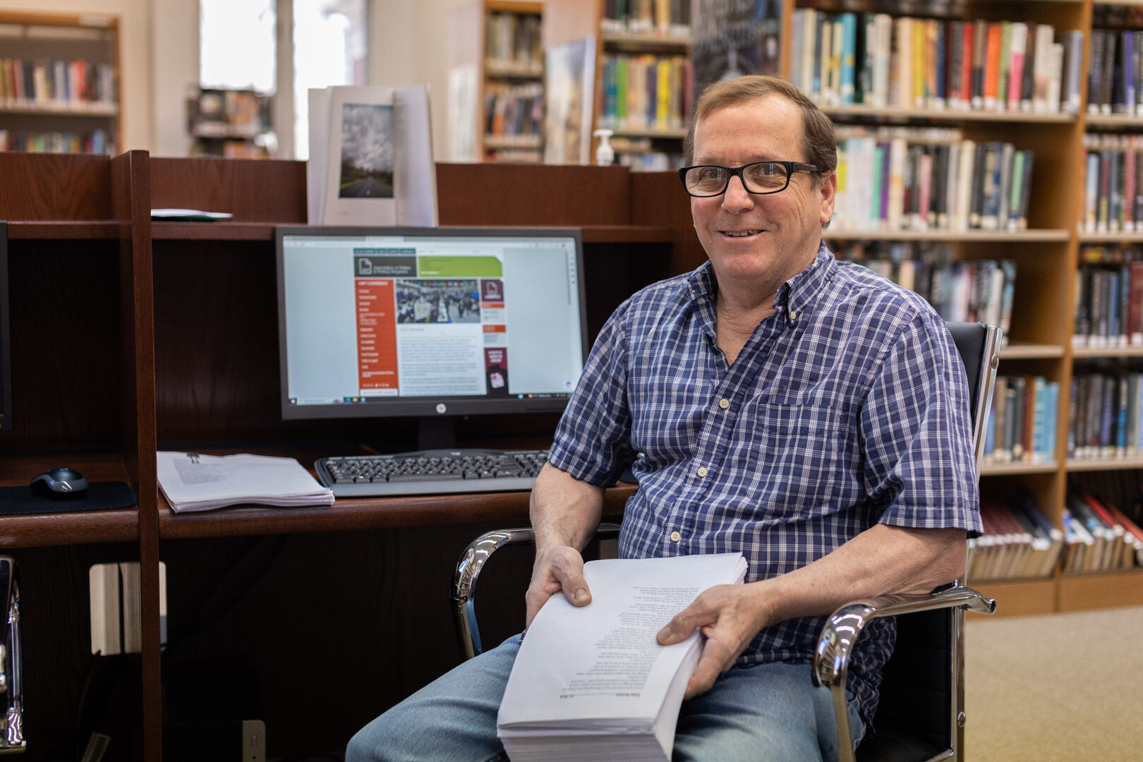 KC Bosch at the library with his manuscripts. A Mitchell grant paid for publication of his book, which is available at the library.