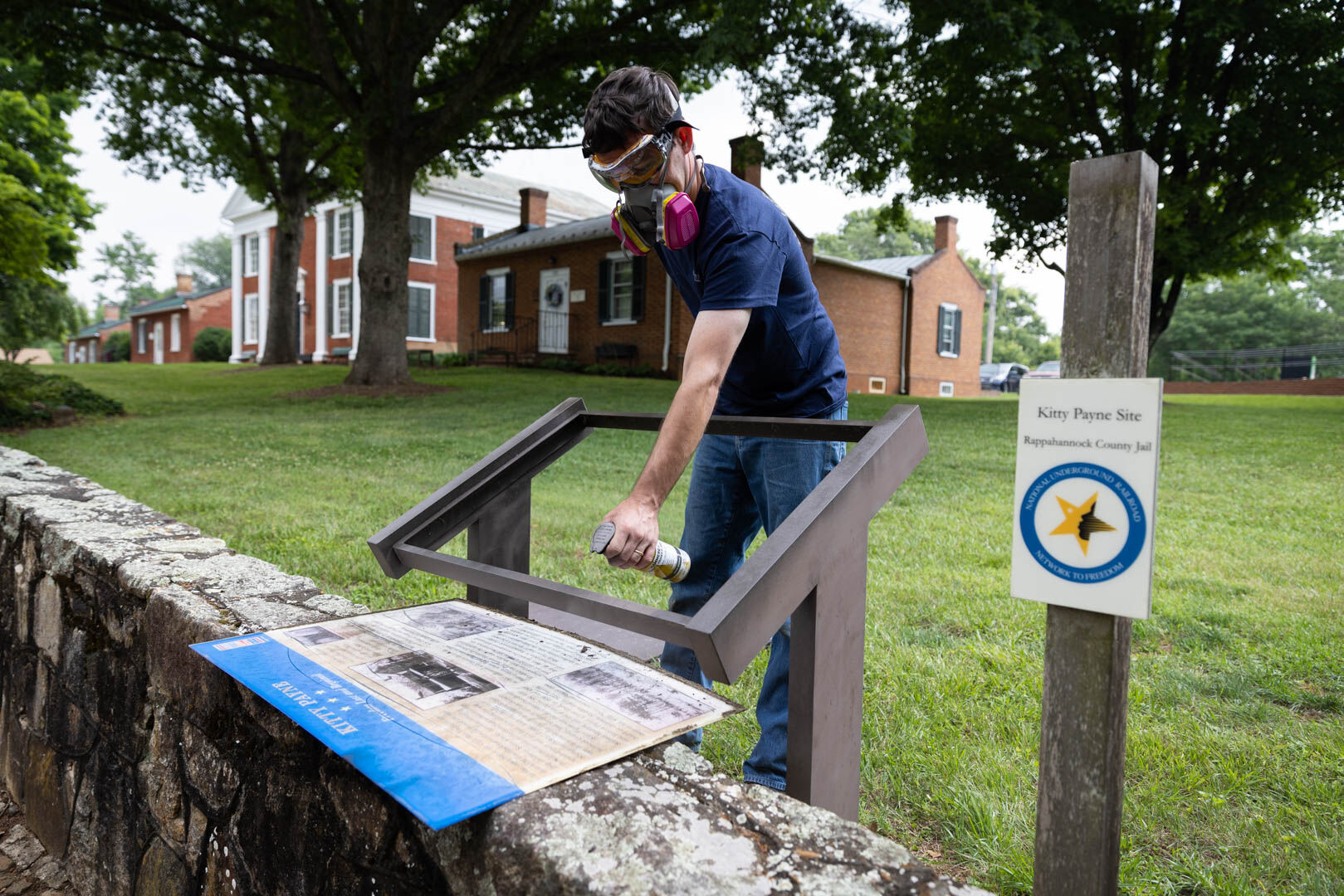 Chris Brown freshens up the paint on the pedestal that holds the panel for Kitty Payne’s remarkable story which includes the Rappahannock County Jail, which is also part of the National Underground Railroad Network to Freedom.