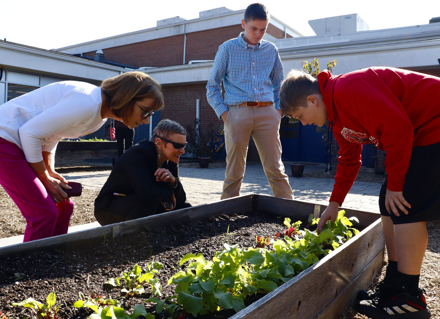 Jason Williams and Bentley Brown show Cindy Long, administrator of Food and Nutritional Services, and Dr. Patty Bennett, regional administrator for the Mid-Atlantic Office, Food and Nutrition Services, fresh lettuce the farm-to-table class is growing in the Rappahannock County Elementary School courtyard. The fresh herbs and vegetables are used in cafeteria meals.