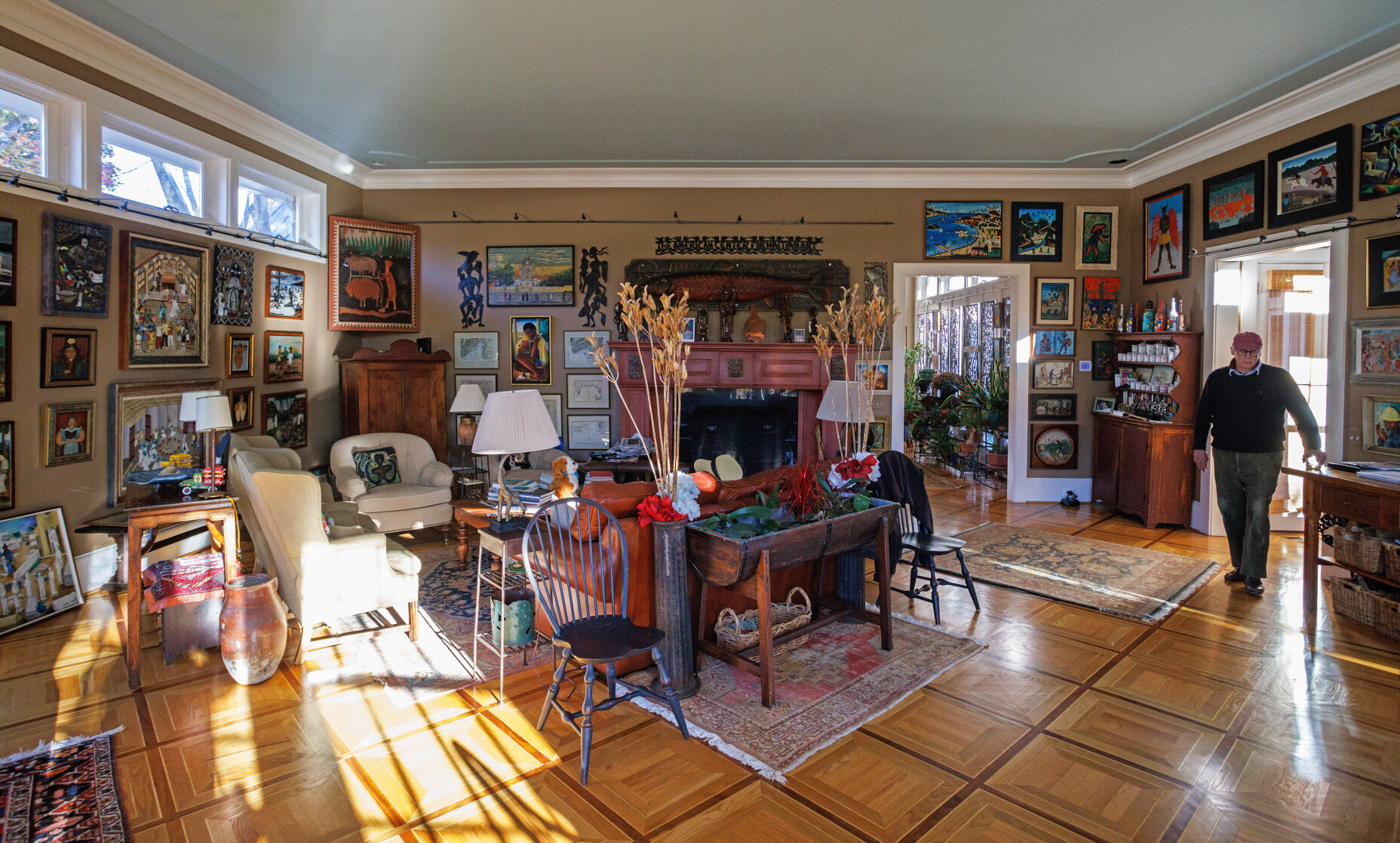 The Sullivans' great room in their Little Washington home stops visitors in their tracks by the impact of bright, colorful Haitian paintings lining the walls. These pieces are part of the Sullivans' 250-piece collection.
