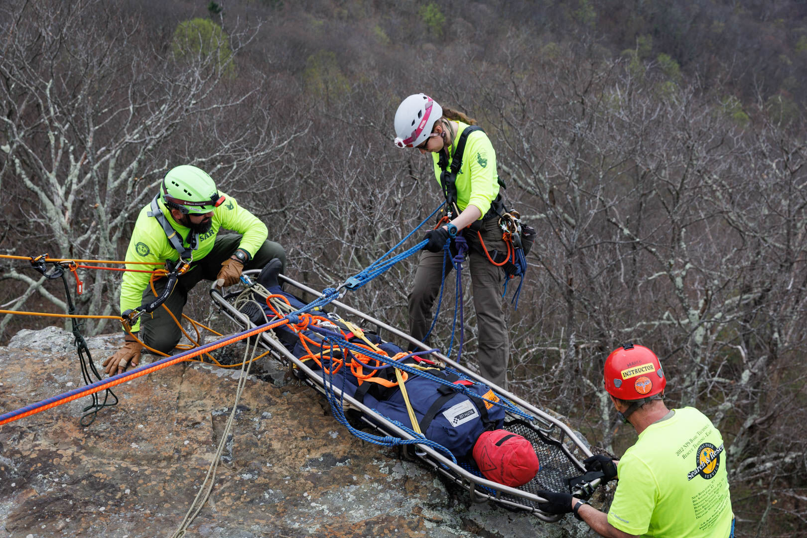 Rehr-Zimmermann prepares to rappel down the cliff with a rescue litter..