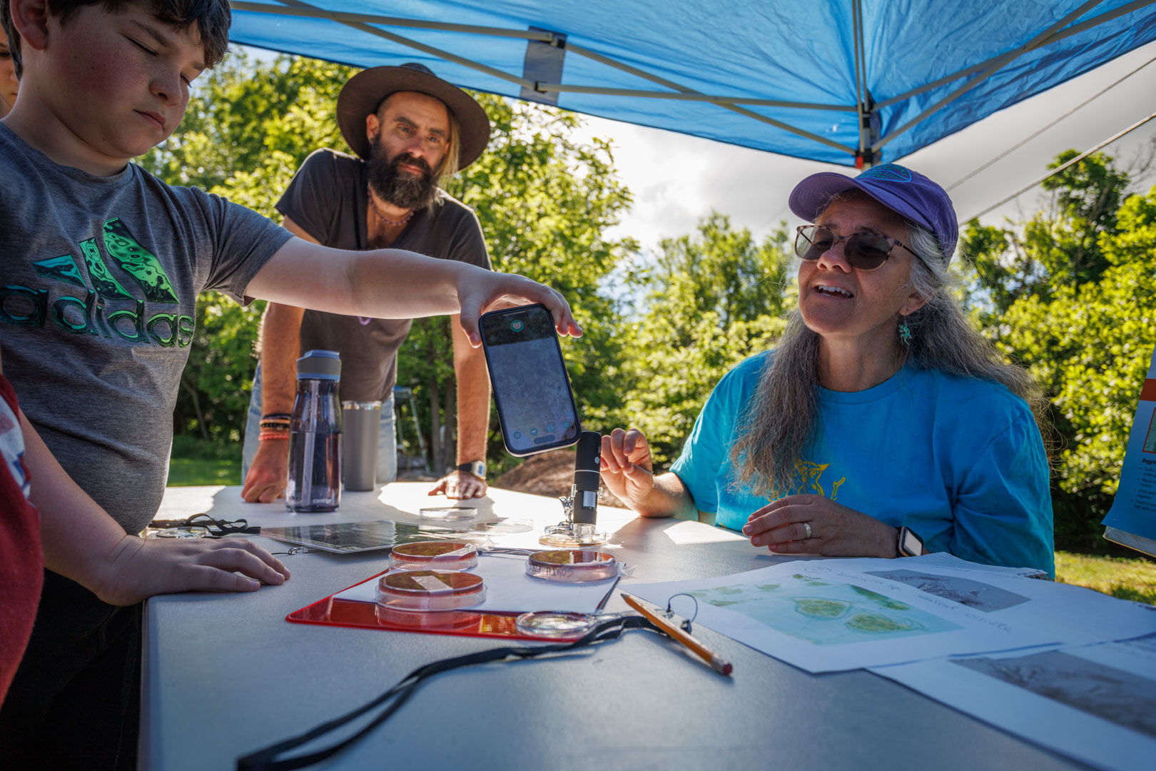 Rachel Bynum tests water samples with Hearthstone School students at the E.Coli and Wastewater station.