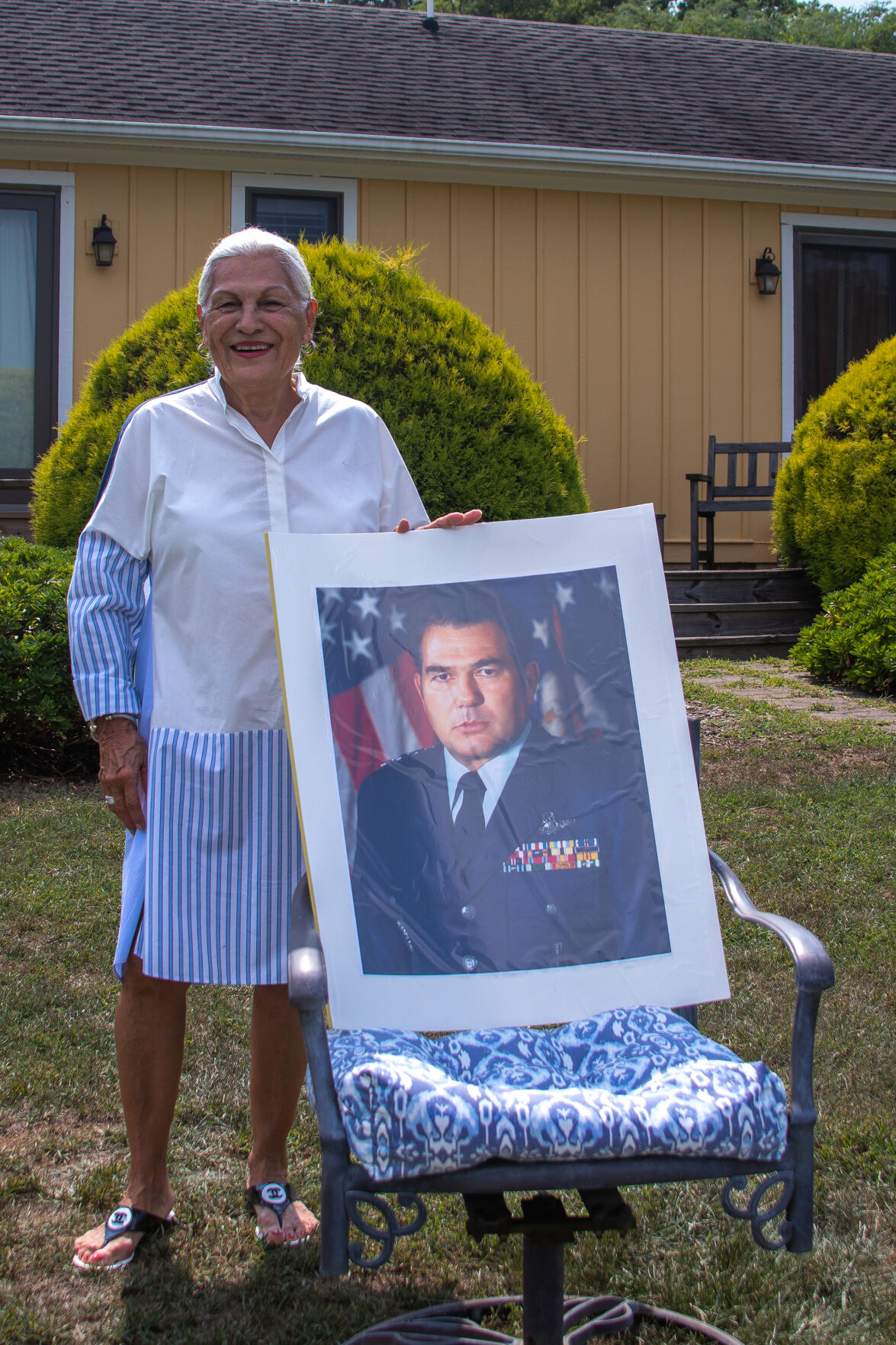 Grace Flores-Hughes standing with a photo of her late husband Lt. Gen. Harley A. Hughes at her home in Castleton.