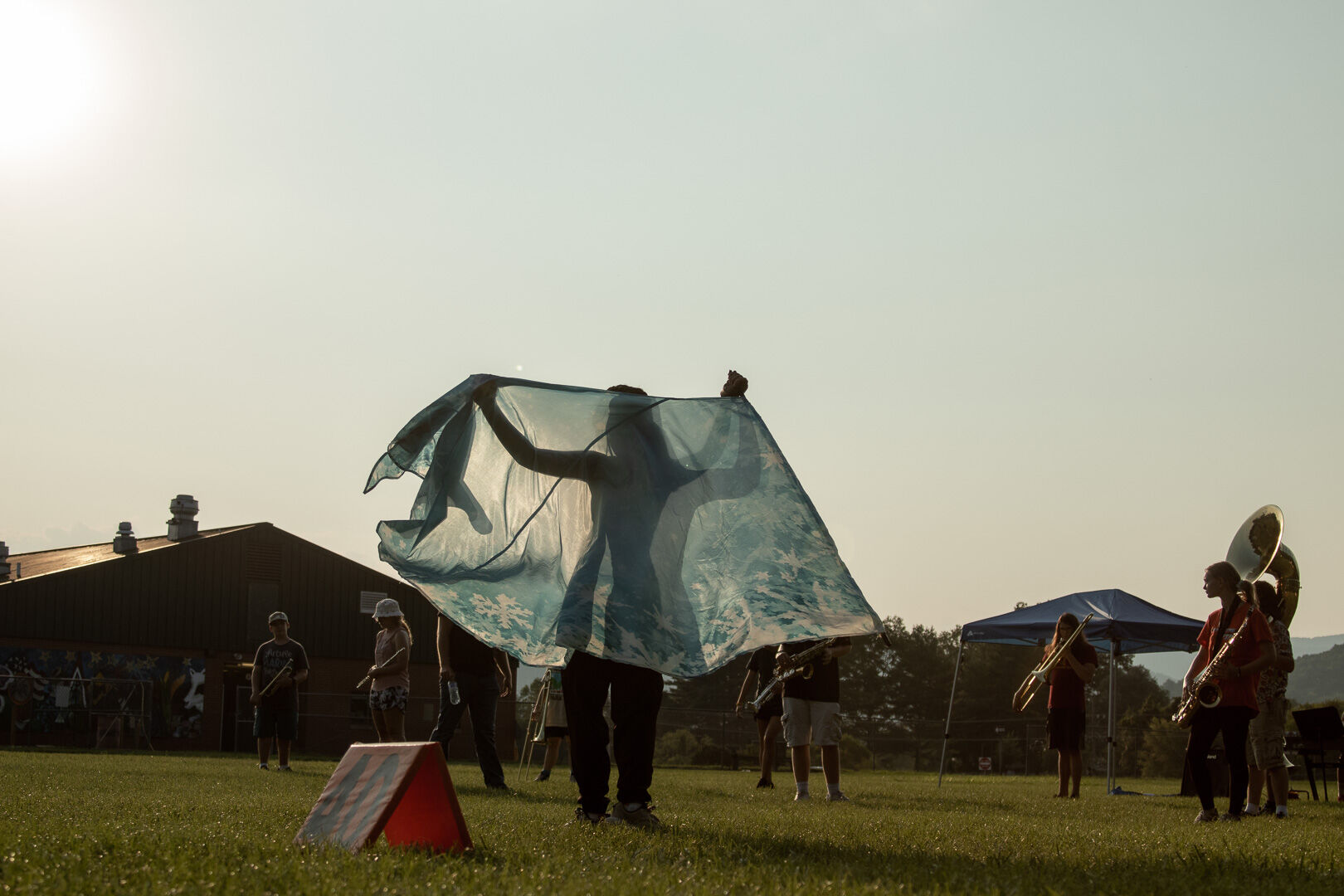 Color guard member Gabby Moreno spins her flag before the full band runs a section of the show. (Photo/Ireland Hayes for Foothills Forum)