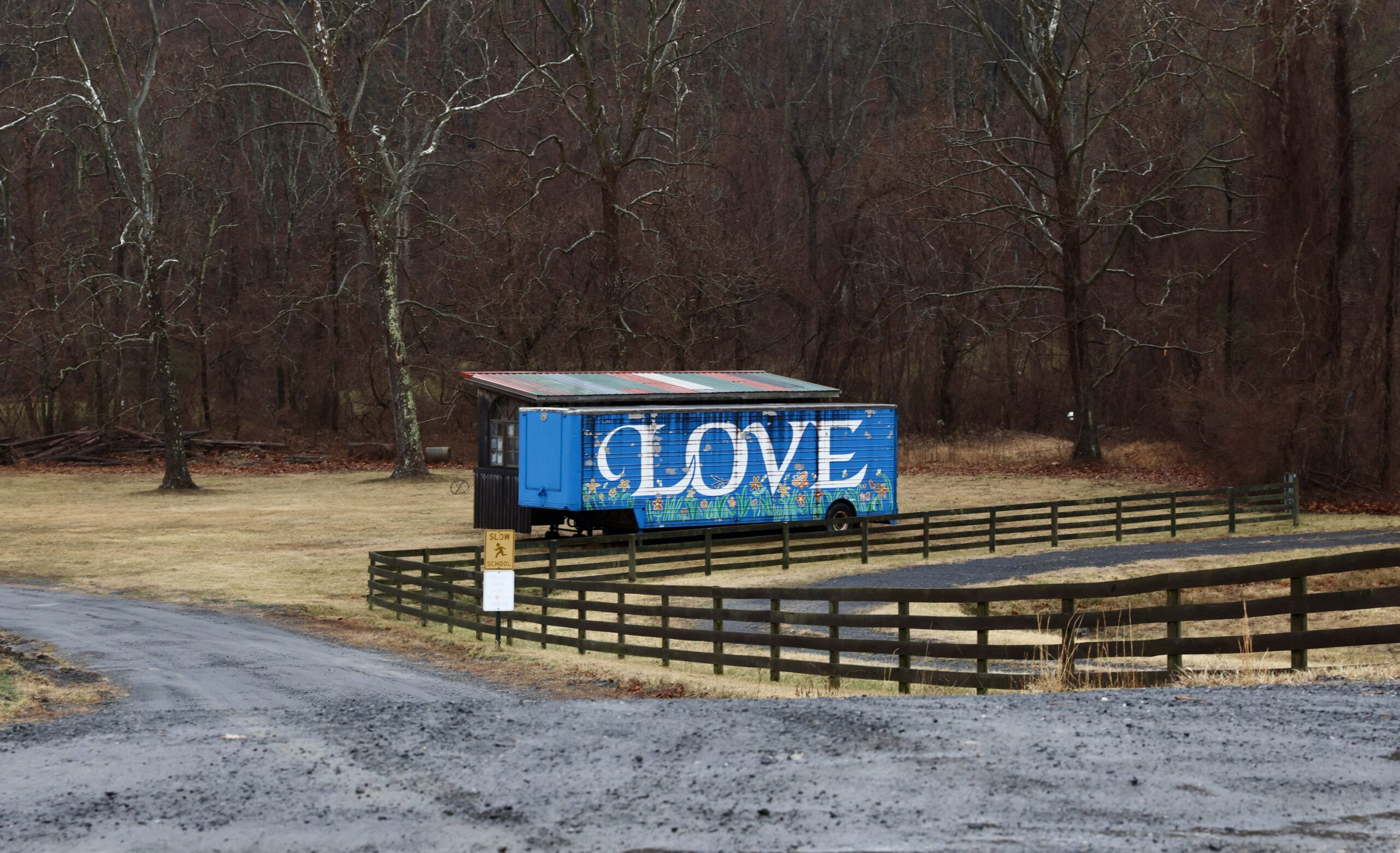 A trailer near the road painted blue with the word love painted